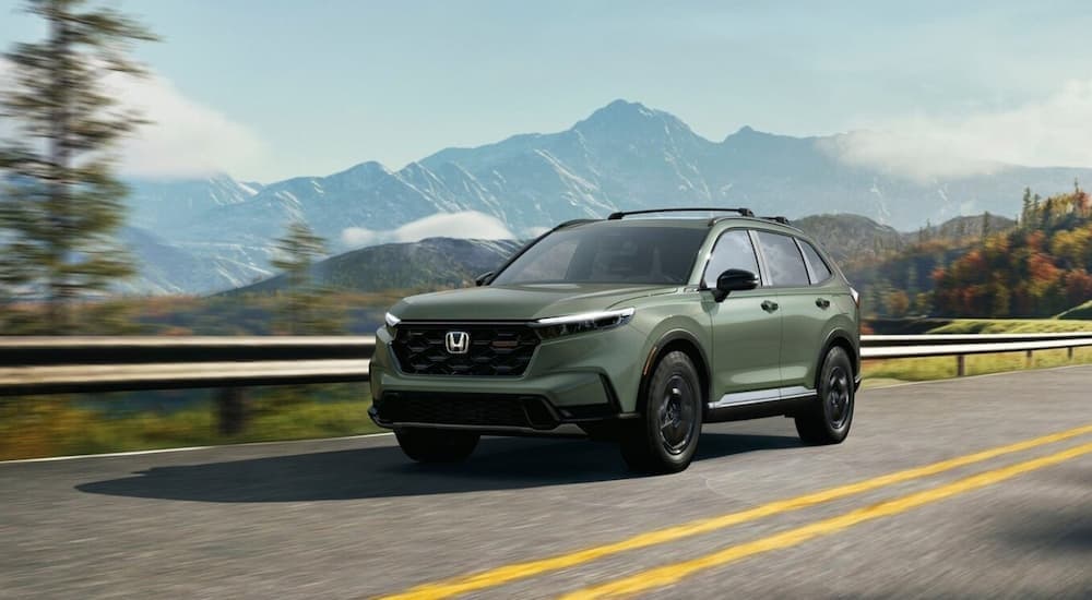 A green 2026 Honda CR-V driving on a highway