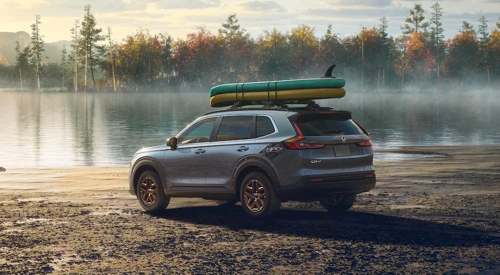 A silver 2025 Honda CR-V Hybrid EX HPD parked at a lake.