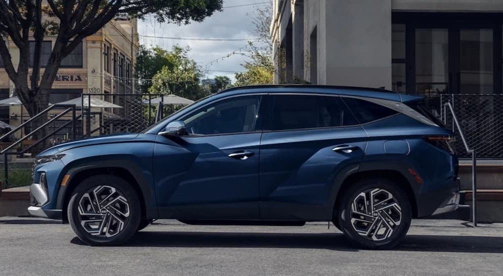 A blue 2026 Hyundai Tucson parked in a city.
