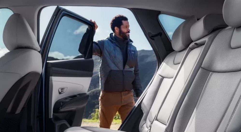 A person opening the door on a 2026 Hyundai Tucson.
