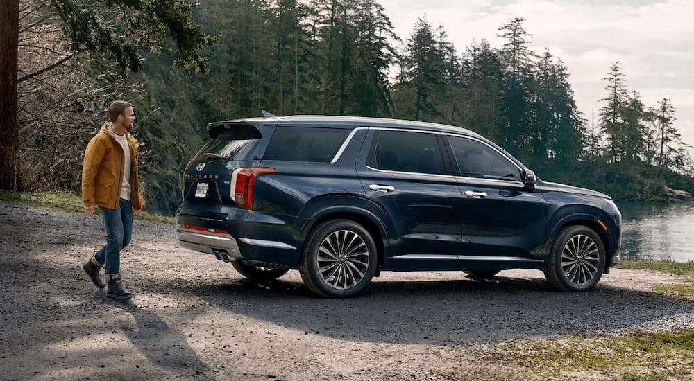 Blue 2025 Hyundai Palisade Calligraphy parked near a lake.