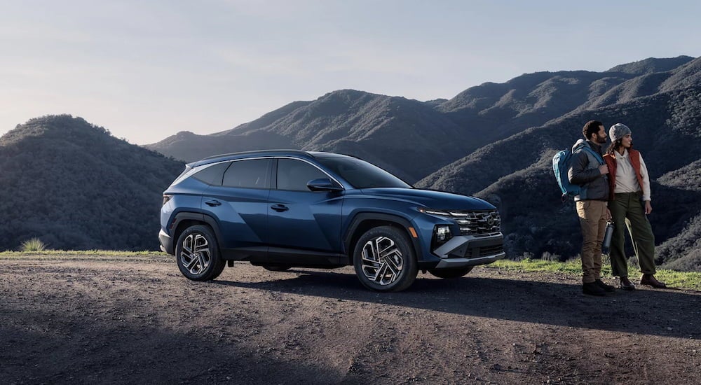 Side of a blue 2026 Hyundai Tucson parked off-road.