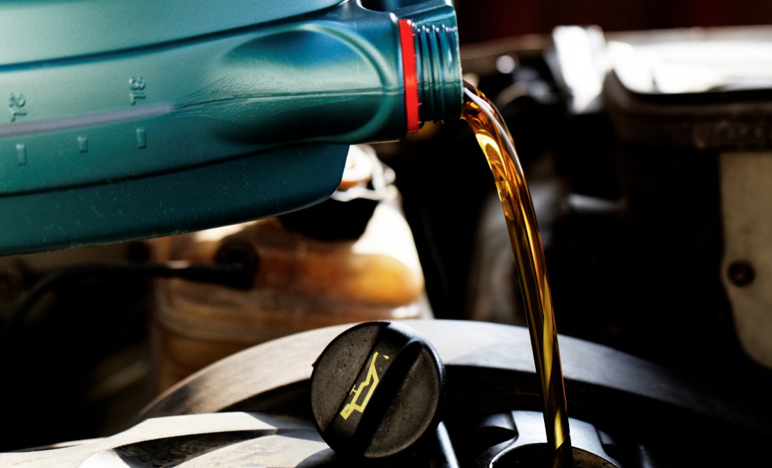 Motor oil being poured into a vehicle during service