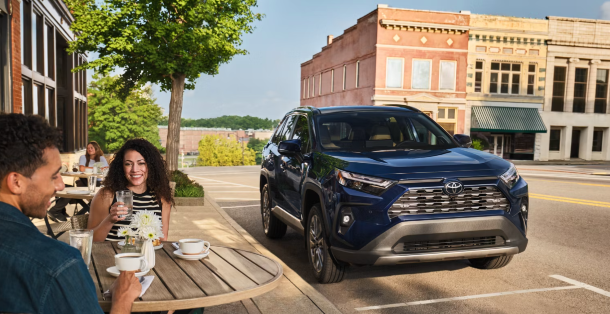 Couple sitting next to a used Toyota RAV4 from Rohrman Toyota in Lafayette