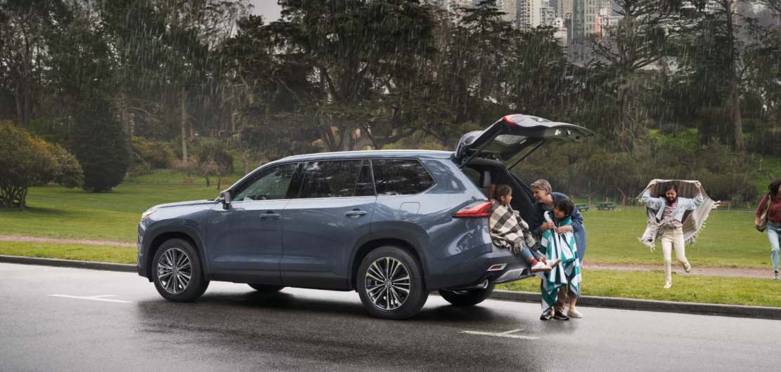 A family gathered around a toyota highlander, the ideal family SUV in Lafayette