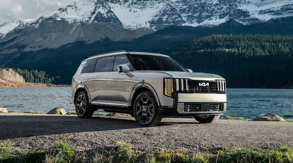 A white 2027 Kia Telluride parked near a lake.