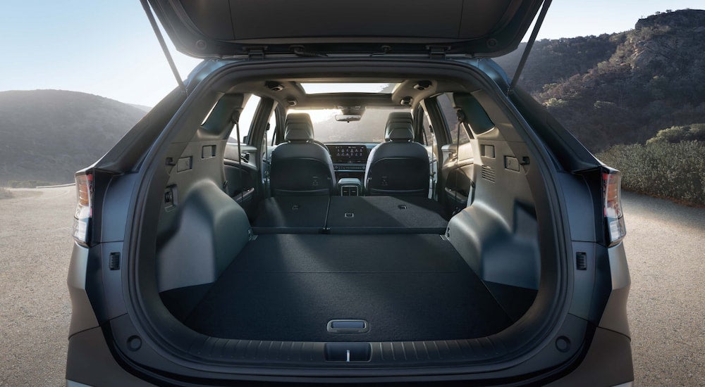 A rear view of a green 2025 Kia Sportage X-Pro with an open hatchback.