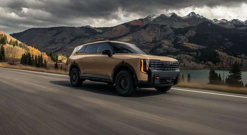 A tan 2027 Kia Telluride driving on a highway.