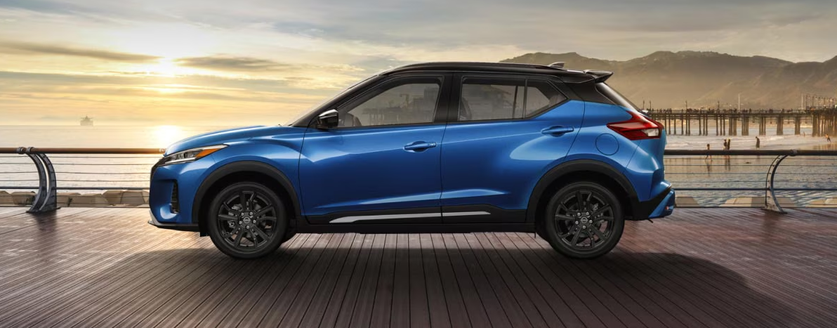 A blue Nissan Kicks parked on a boardwalk at sunrise