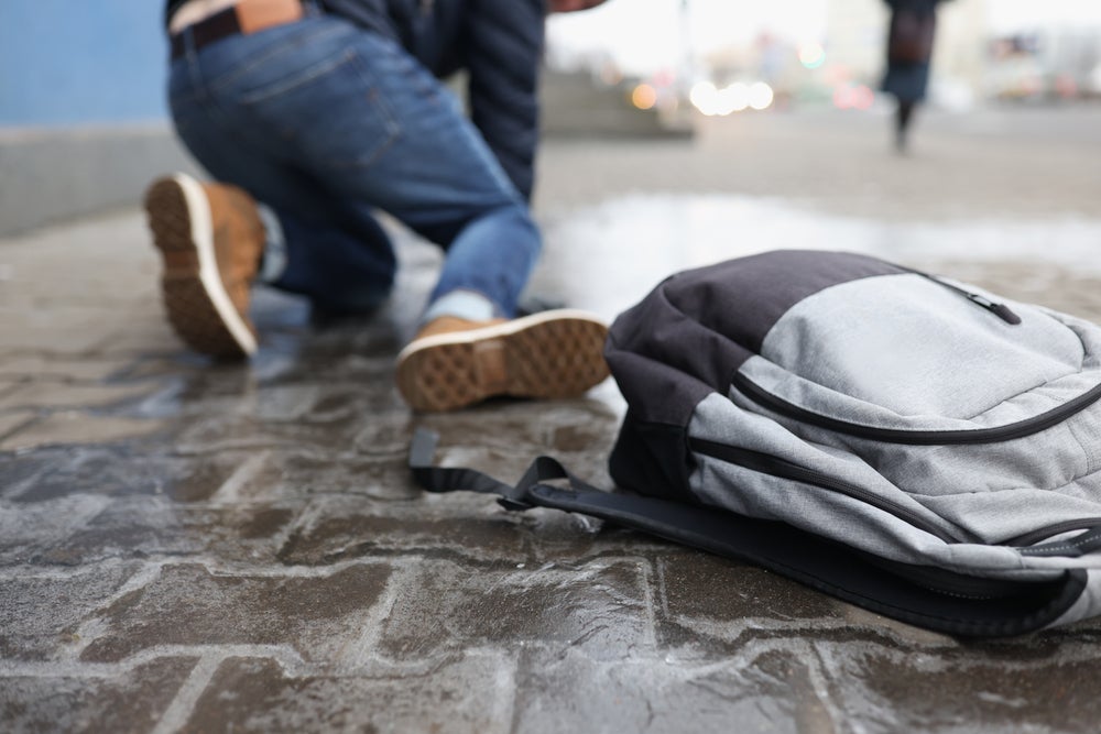 Man,With,Backpack,Felling,On,Slippery,Sidewalk,In,Winter,Closeup