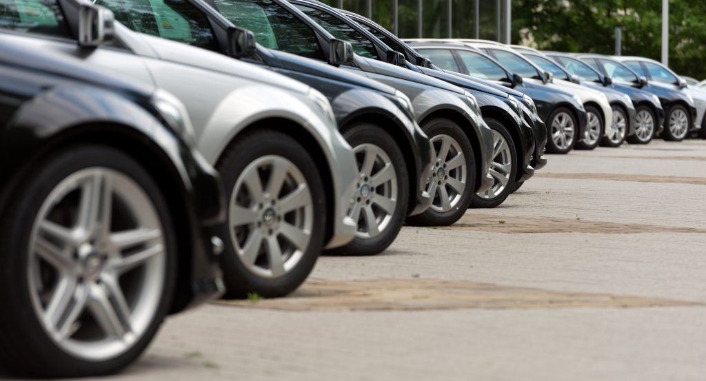 Side view of a row of certified pre-owned vehicles lined up in a dealership lot, highlighting multiple cars parked in sequence with polished exteriors and uniform presentation.