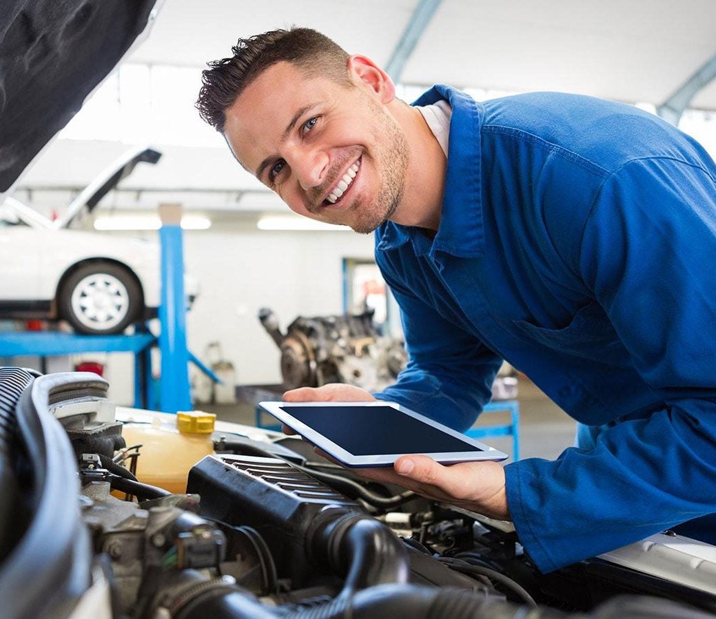 Service tech looking at car engine