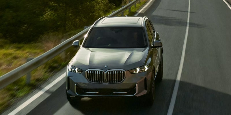 2026 BMW X5 driving on a winding road
