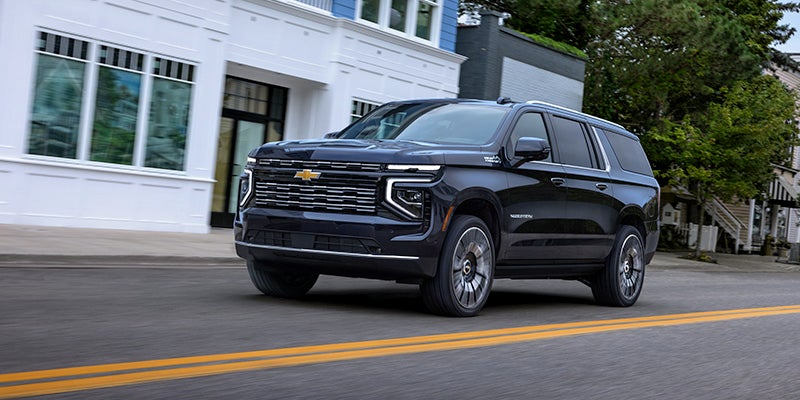 A 2025 Chevy Suburban driving down a city street.