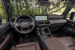 2027 Toyota Land Cruiser interior with multimedia touchscreen display, steering wheel, and premium brown seating