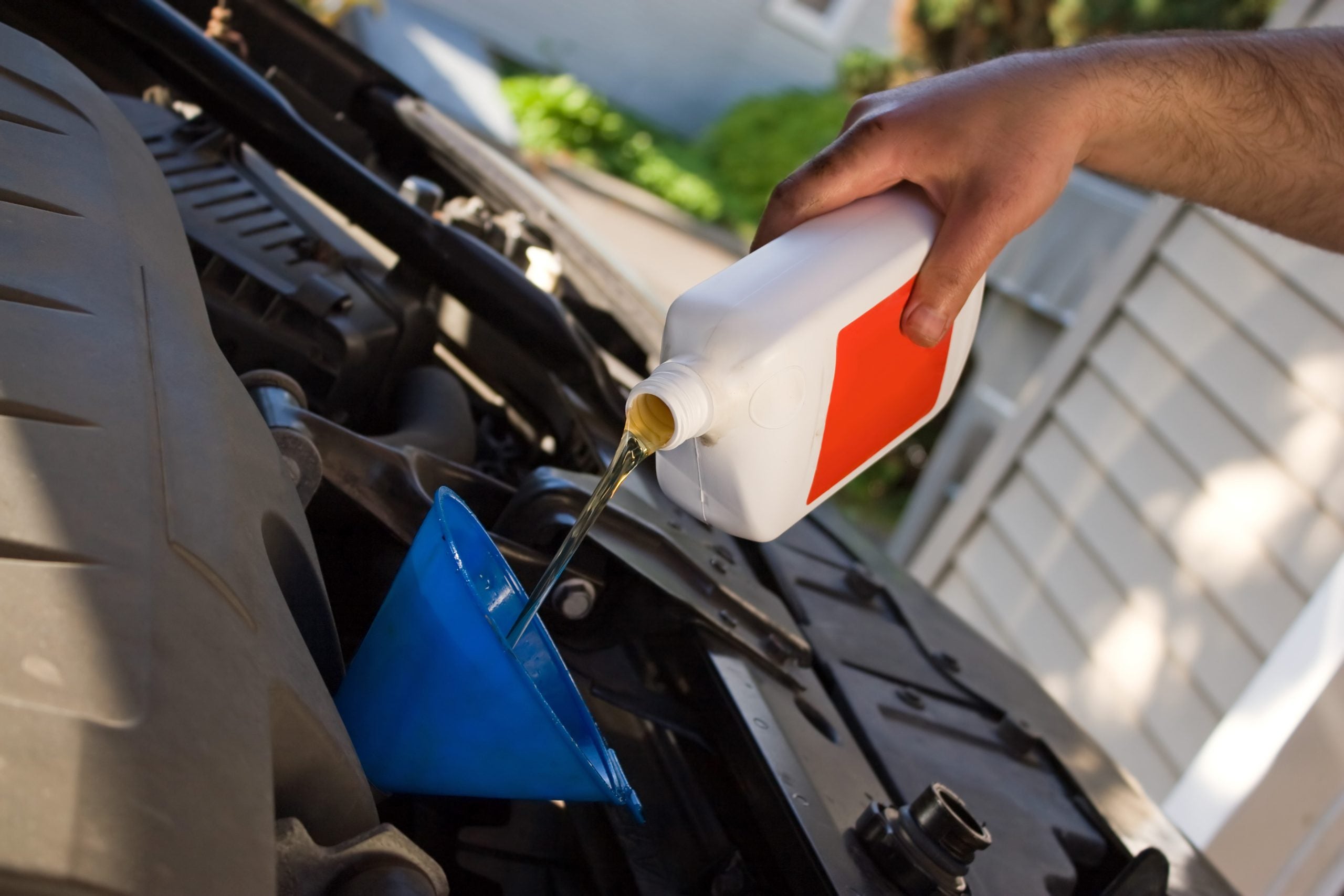 Person conducting an oil change on a car