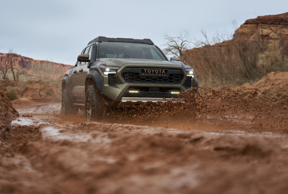 2026 Toyota Tacoma driving through a muddy terrain