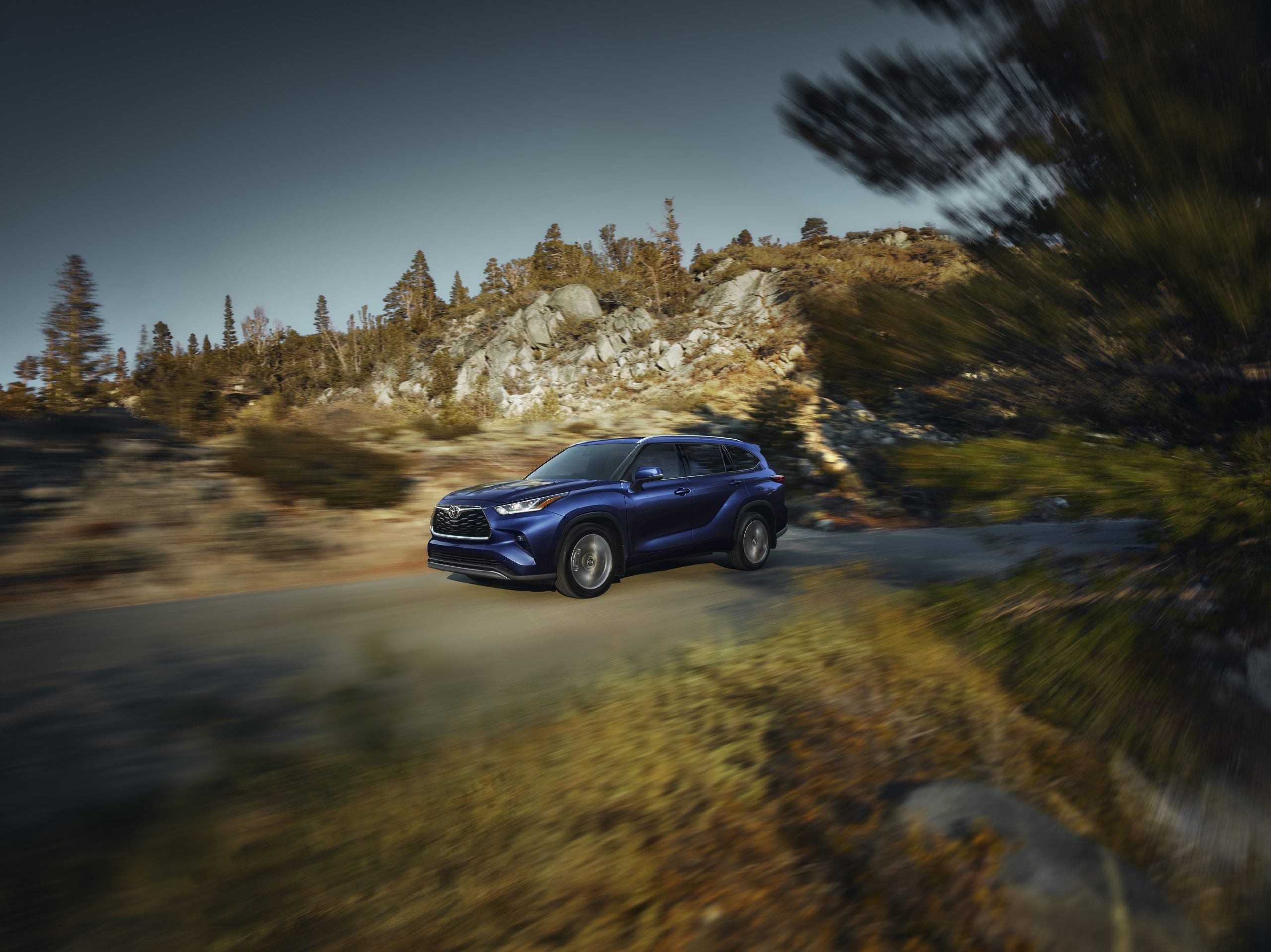 2026 Toyota Highlander Blue driving in the mountains