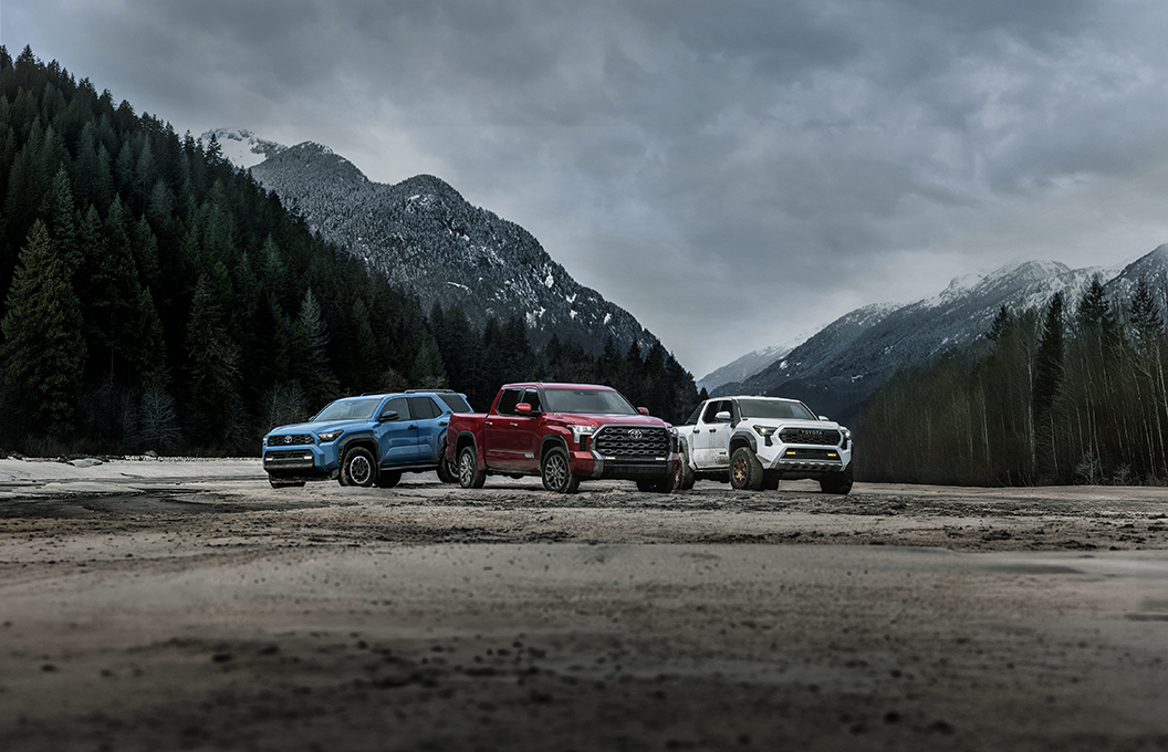 Toyota cars and trucks lined up in front of a mountain