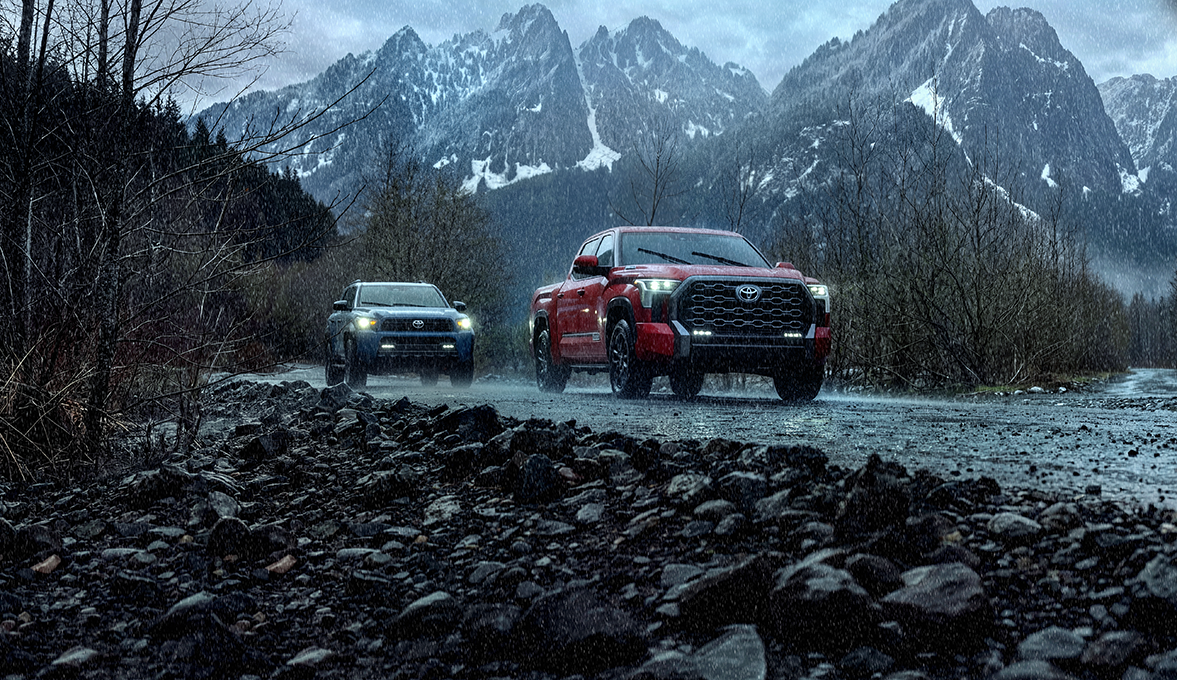 Toyota Tundra's driving in the rain on a slippery road