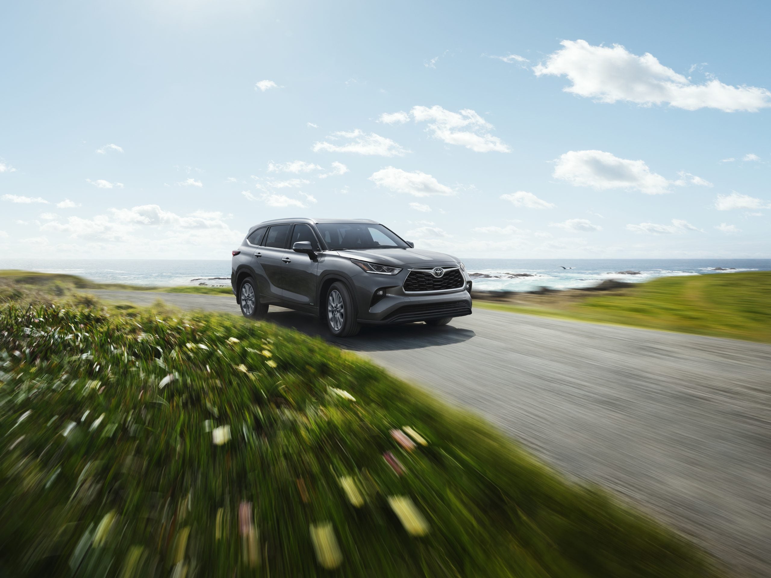 2026 Toyota Highlander driving through a field