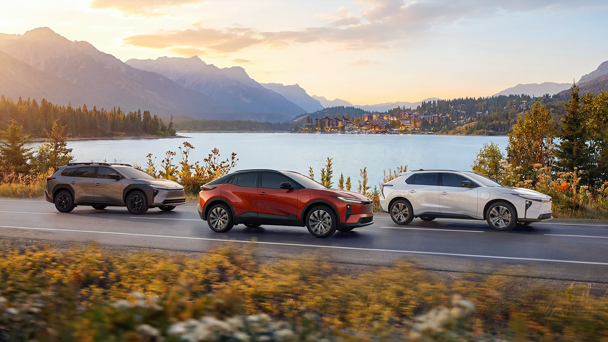 Toyota cars driving on a road in front of a lake