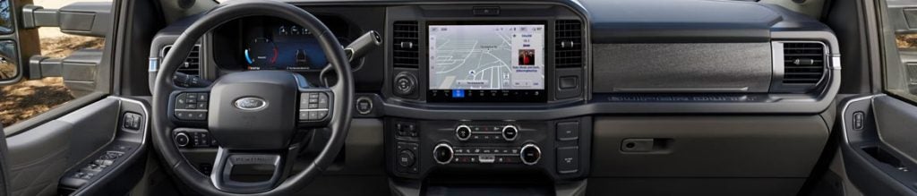 Interior view of a 2026 Ford truck featuring a modern dashboard, large touchscreen display, steering wheel controls, and climate control system.