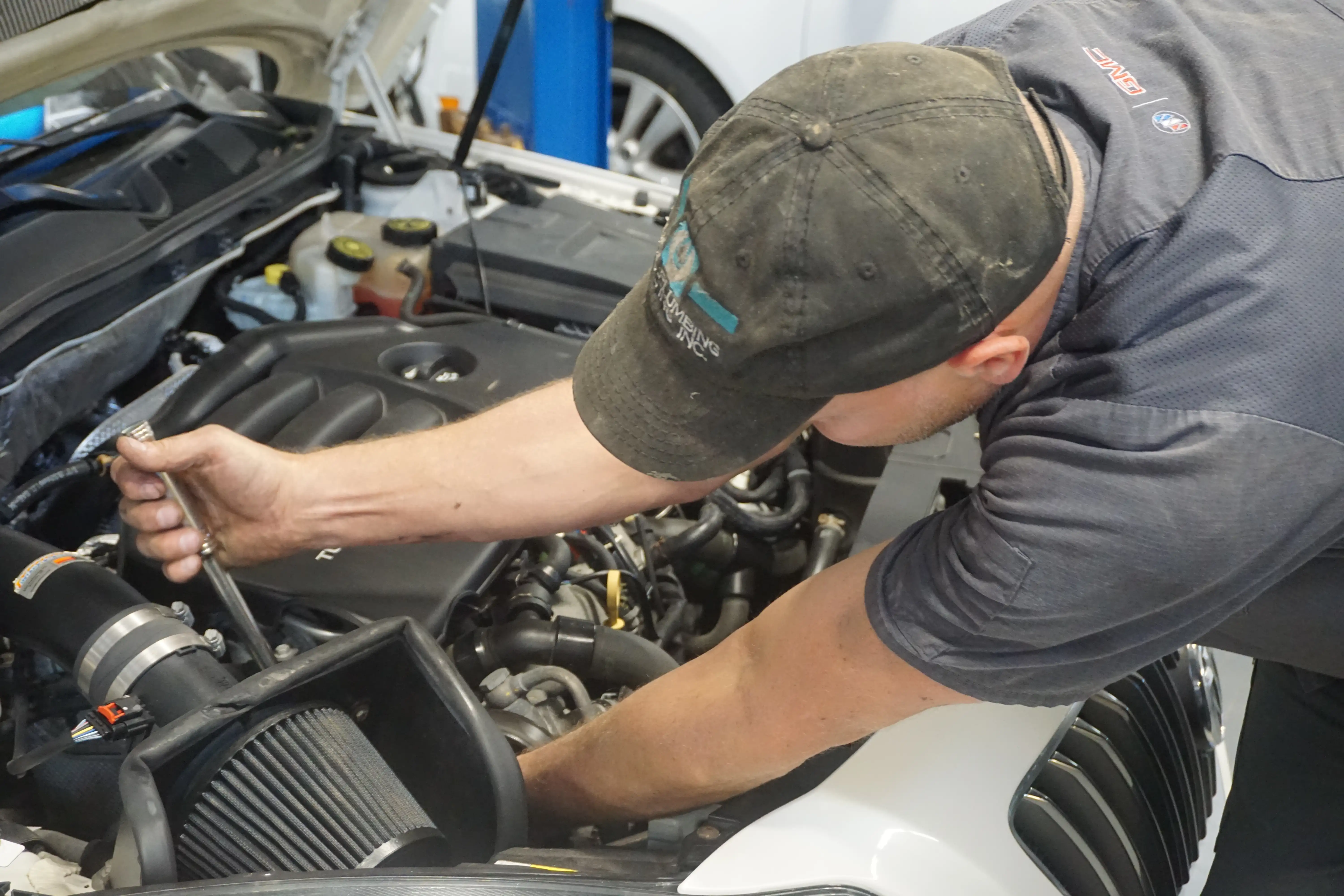 M technician with lineup of GM trucks getting serviced