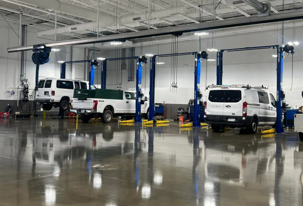  Ford technician with lineup of Ford trucks getting serviced 