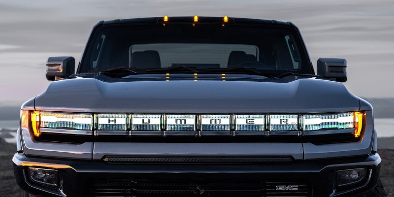 Front view of a GMC Hummer EV with illuminated light bar and grille.