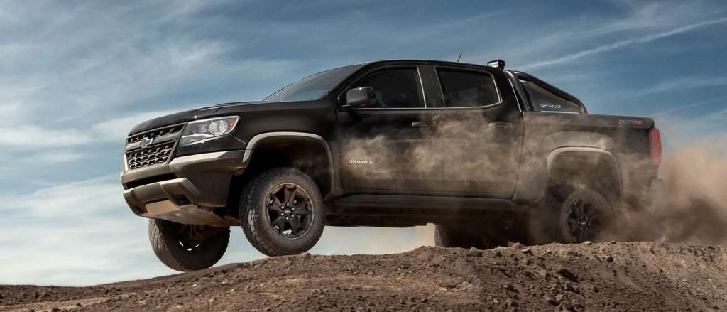 black truck driving through dust