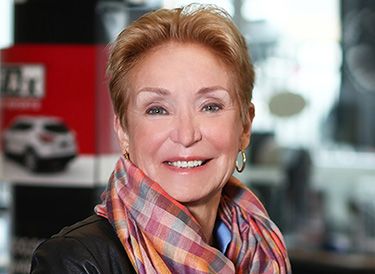 a woman wearing a red scarf smiling at the camera
