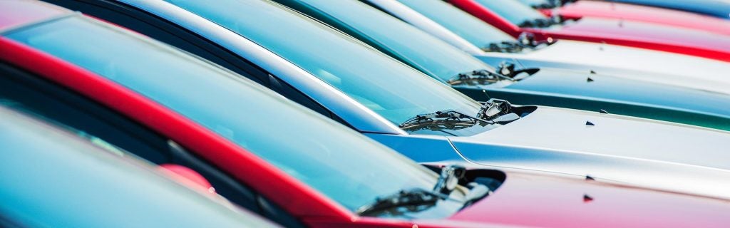 Row of colorful cars parked on a lot.