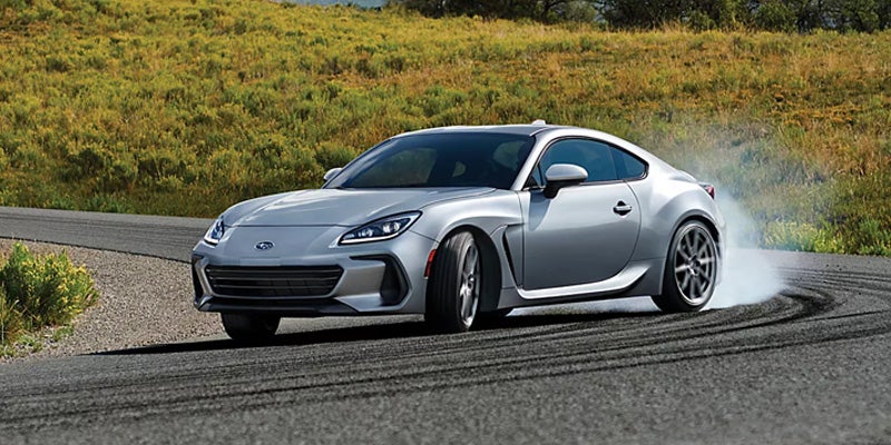 Silver Subaru BRZ drifting on a mountain road.
