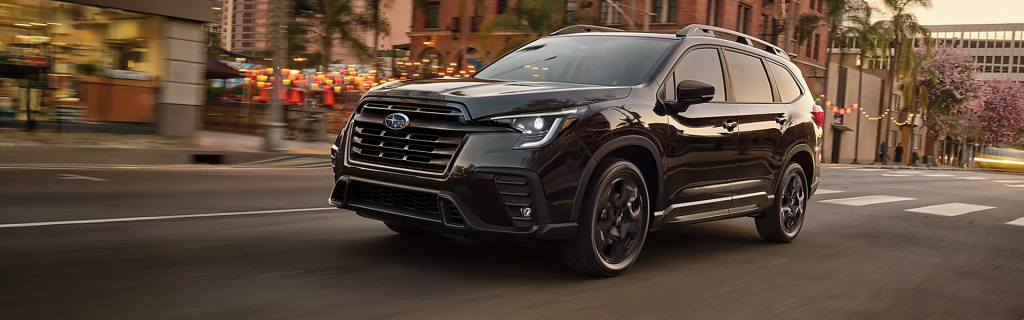 Black Subaru SUV driving on a city street