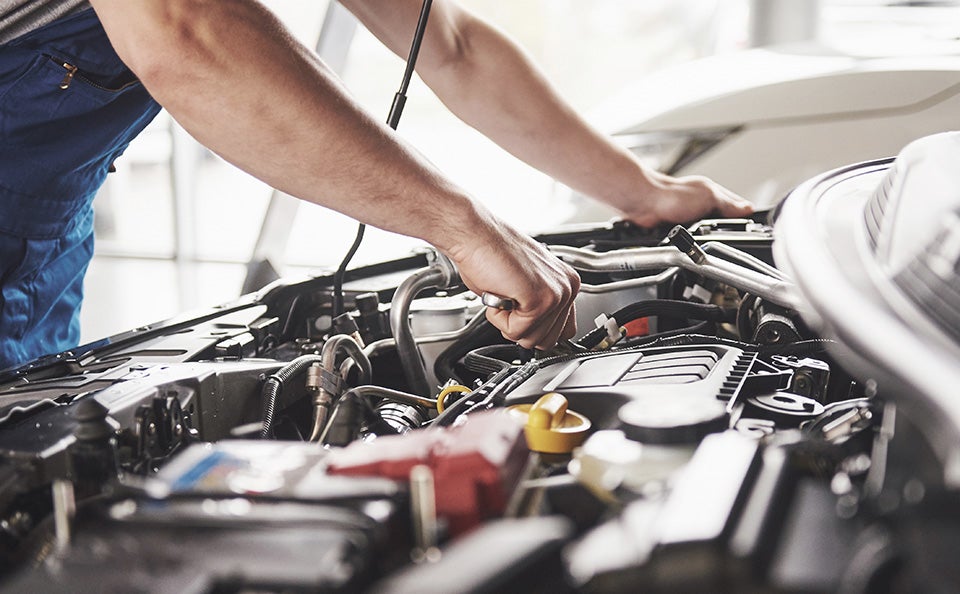 GMC technician performing summer maintenance on a GMC vehicle.