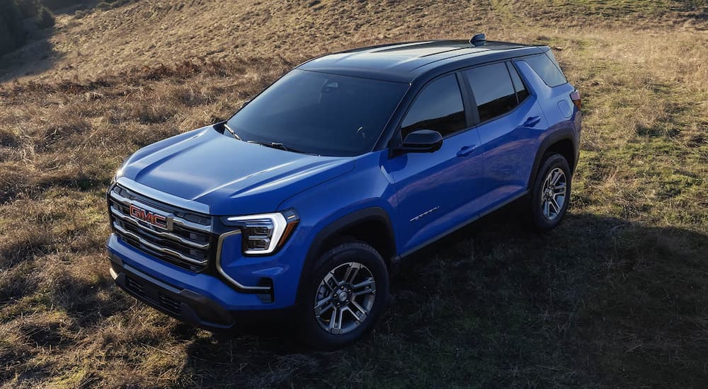 Blue 2026 GMC Terrain parked in a field.