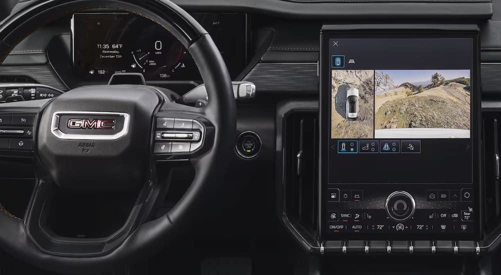 Close-up of steering wheel and infotainment screen in a 2025 GMC Acadia.