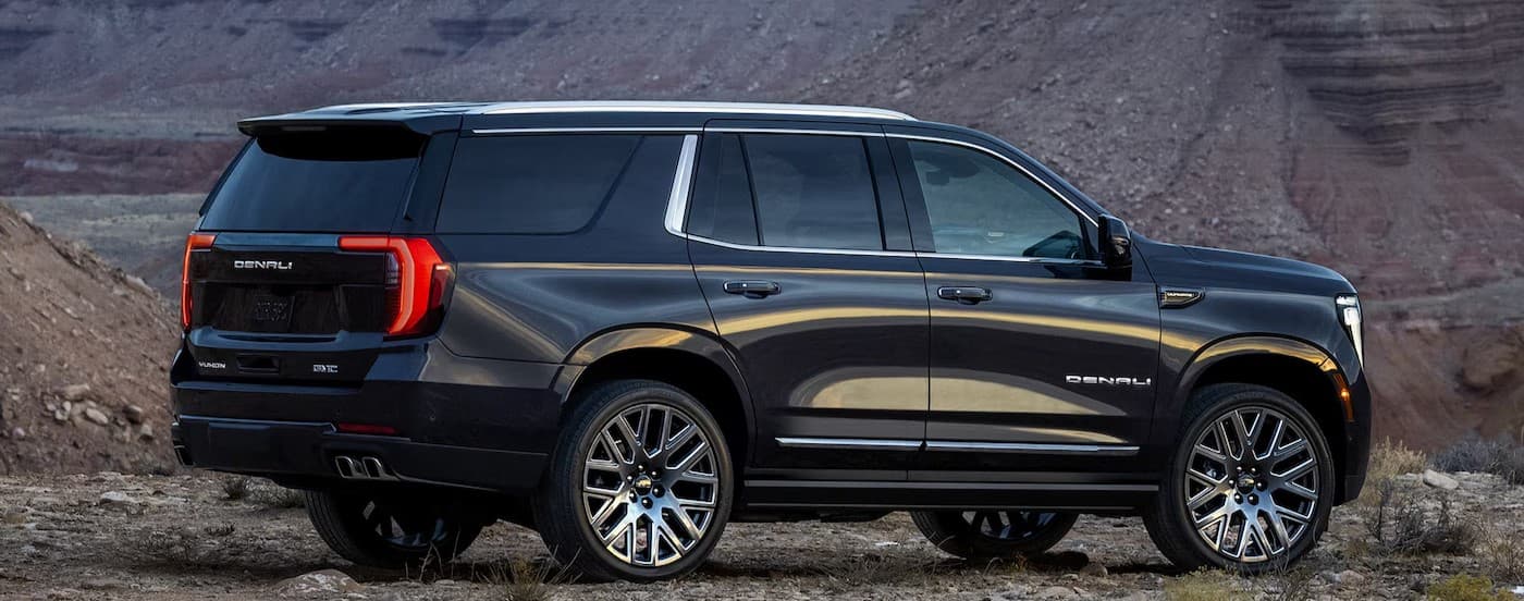A black 2025 GMC Yukon Denali parked offroad.