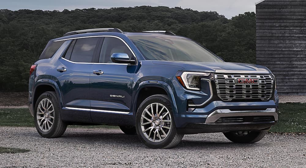 Blue 2026 GMC Terrain Denali parked near a building.