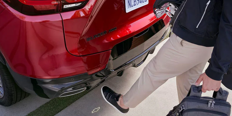 A person opening the trunk of their 2025 Chevy Blazer near Fort Gratiot, MI