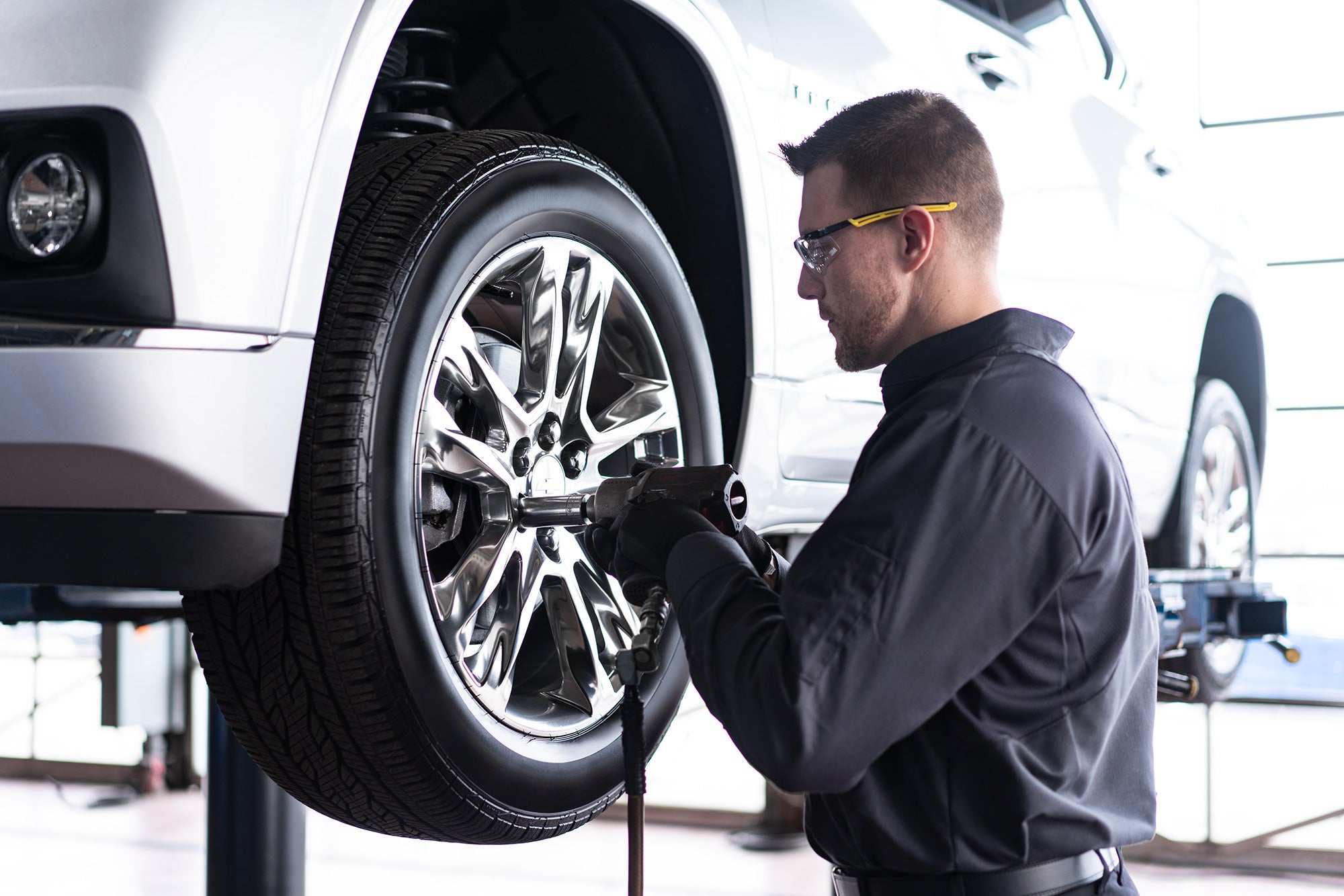 Chevy service technician rotating tires