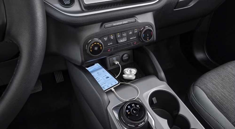 Ford%20Dealer%20Near%20Morganfield%20-%202024%20Ford%20Bronco%20Sport%20Big%20Bend%20-%20%20Airpods%202.jpg A smartphone and earbuds are shown in a 2024 Ford Bronco Sport Big Bend.