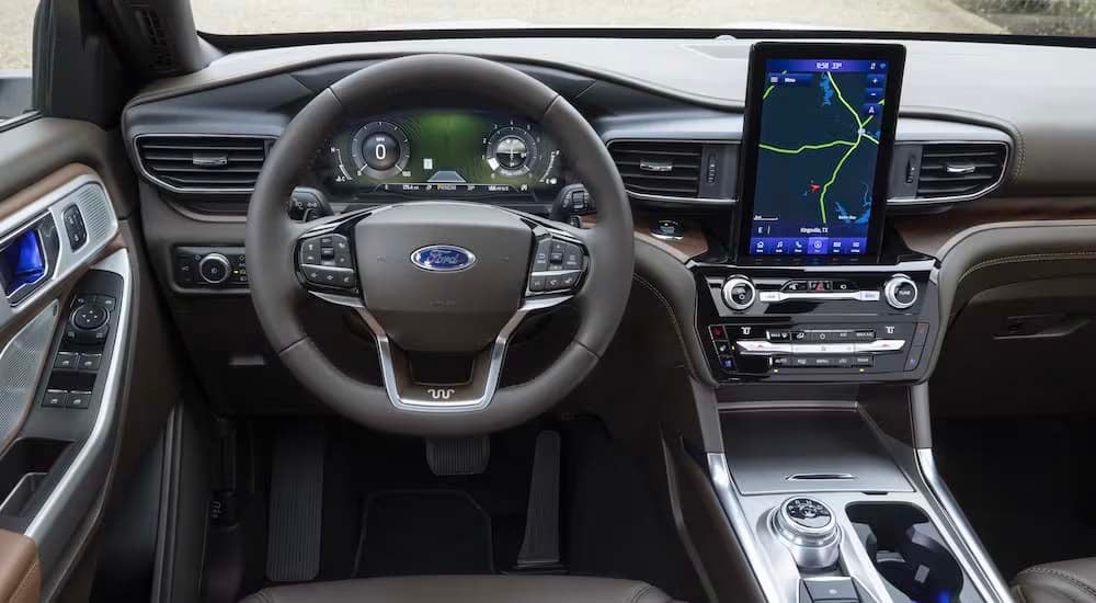 The grey interior of a 2022 Ford Explorer King Ranch shows the steering wheel and center console.