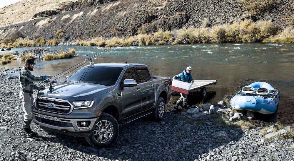 A grey 2021 Ford Ranger Lariat is shown by a riverbed as people unpack fishing gear.