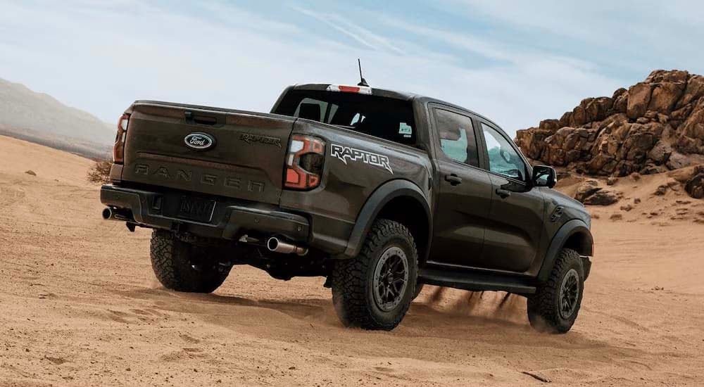 Ford%20dealer%20near%20Madisonville%20-%202024%20Ford%20Ranger%20Raptor%20-%20Rear%20Sand.jpg A green 2024 Ford Ranger Raptor is driving on sand.