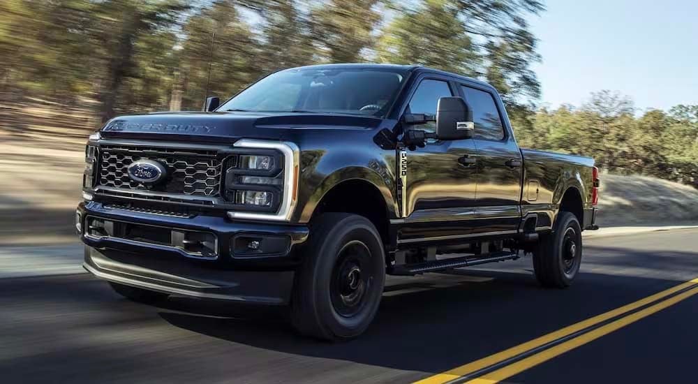 Ford%20dealer%20near%20Madisonville%20-%202024%20Ford%20F-250%20Super%20Duty%20STX%20-%20Black.jpg A black 2024 Ford F-250 Super Duty STX is driving on a winding road.