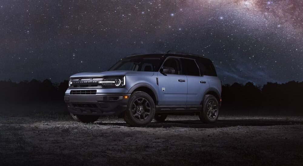 A blue 2024 Ford Bronco Sport Big Bend is shown parked at night after visiting a Ford dealer near Ne…