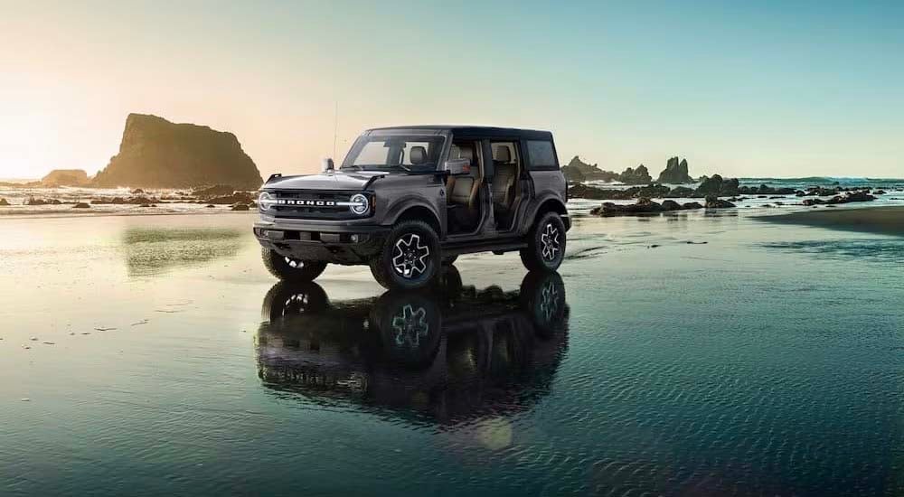 A gray 2024 Ford Bronco Outer Banks is shown parked on water after visiting a Ford dealer near Mount…