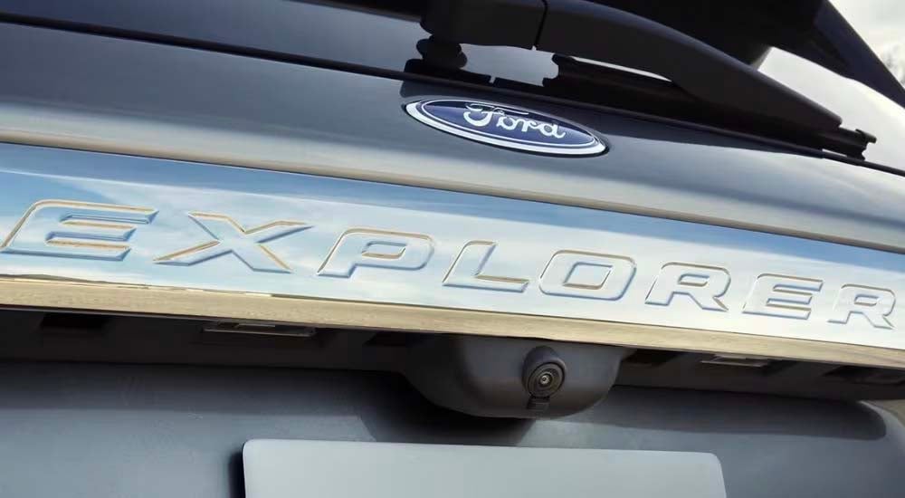 A close up shows the 'Explorer' badge on a silver 2022 Ford Explorer.